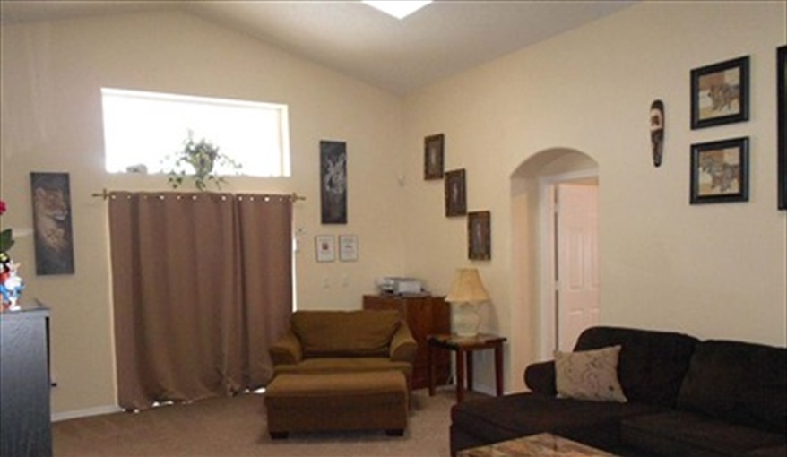 Great family lounge with a comfy armchair, High ceilings & Doors out to the Covered Lanai.. Disney on Your Doorstep in Indian Creek, Kissimmee, Orlando
