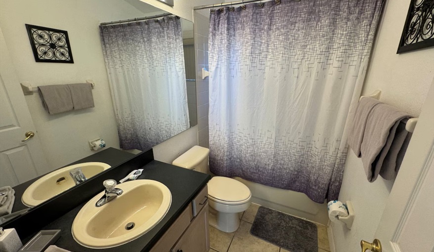 The well-appointed guest bathroom features vanity sink, tub/shower combination. Daisy's Den  in Indian Ridge, Kissimmee, Orlando
