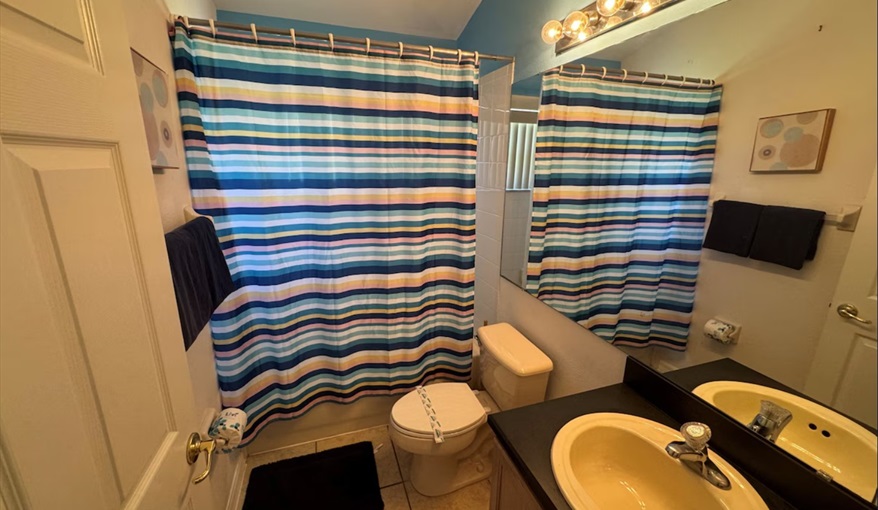 The fourth bathroom showcases vibrant beach-theme. Daisy's Den  in Indian Ridge, Kissimmee, Orlando