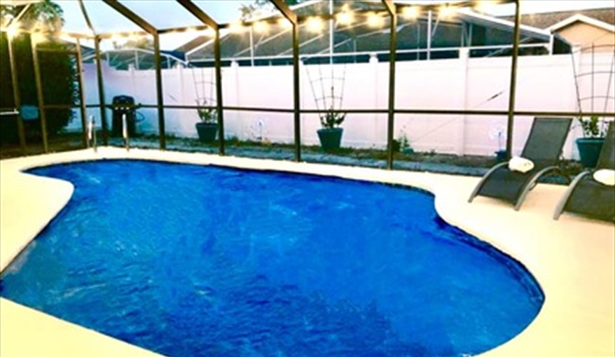 As the sun sets, the outside lighting allows for the pool area to continue being used. Ref 993PF. Family home, free BBQ. Near Disney. Pet friendly in Lindfields, Kissimmee, Orlando