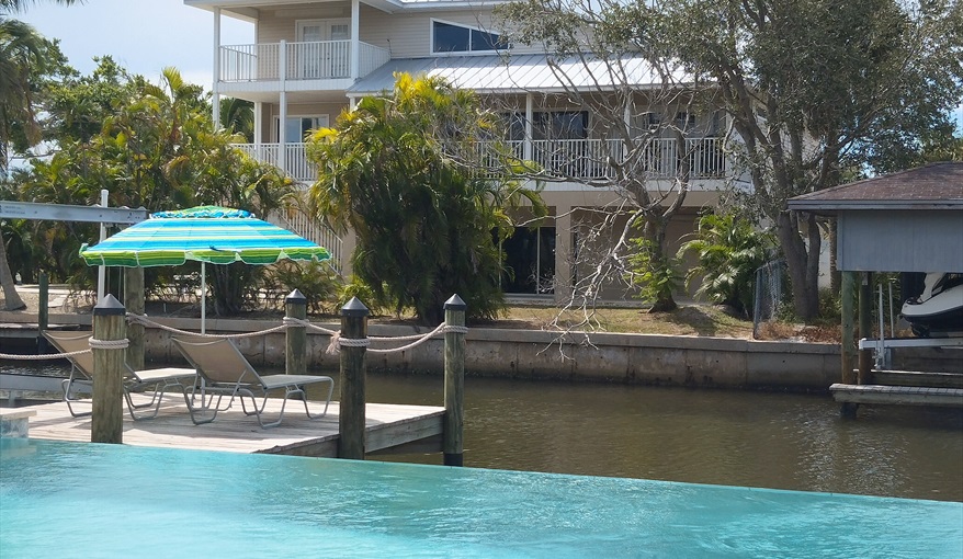 Infinity Edge and Dock seen from the sitting and dining areas on the upper deck. Island Villa with 33 Foot Infinity Pool, Dock, Dolphin Visits in Fort Myers Beach, Fort Myers, Gulf Coast