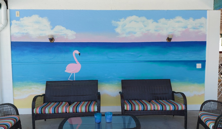 Upper pool deck shaded sitting area with mural (copyright Jessica and Larissa).. Island Villa with 33 Foot Infinity Pool, Dock, Dolphin Visits in Fort Myers Beach, Fort Myers, Gulf Coast